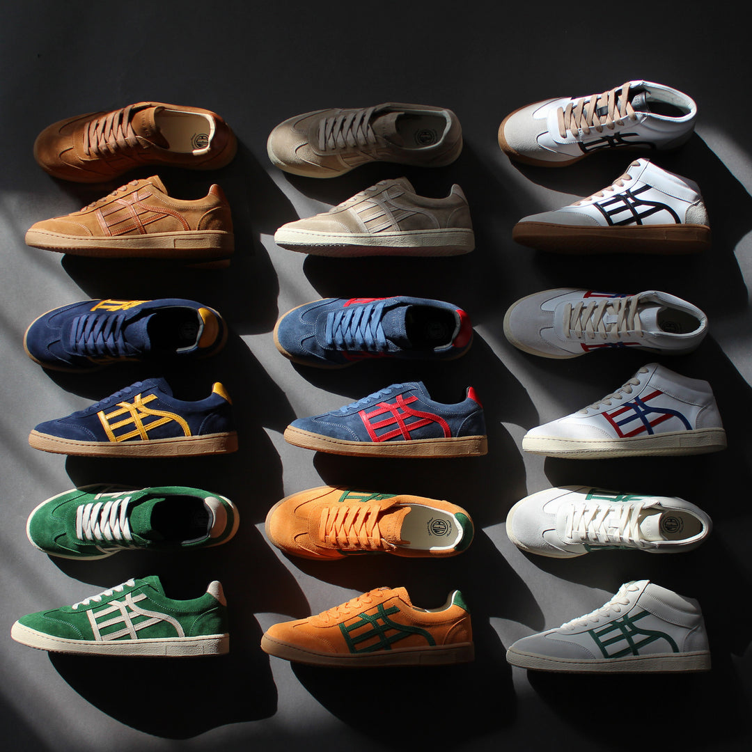 Different colored sneakers arranged in a grid on a grey background.