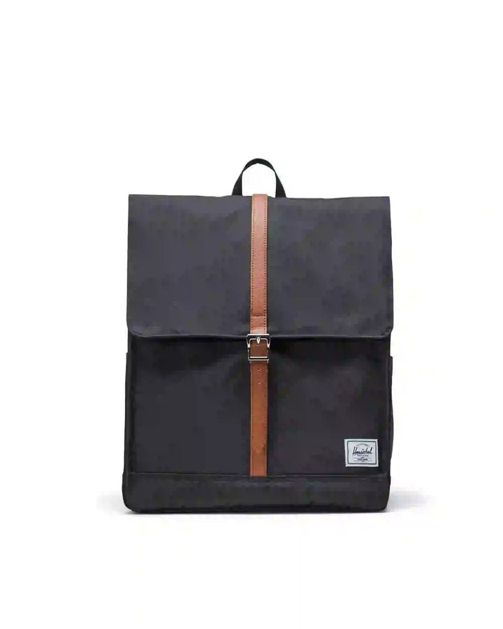 A Herschel City Backpack with a sleek design, featuring a black body with a brown leather-like strap and buckle, and a small white tag with the Herschel logo on the front.