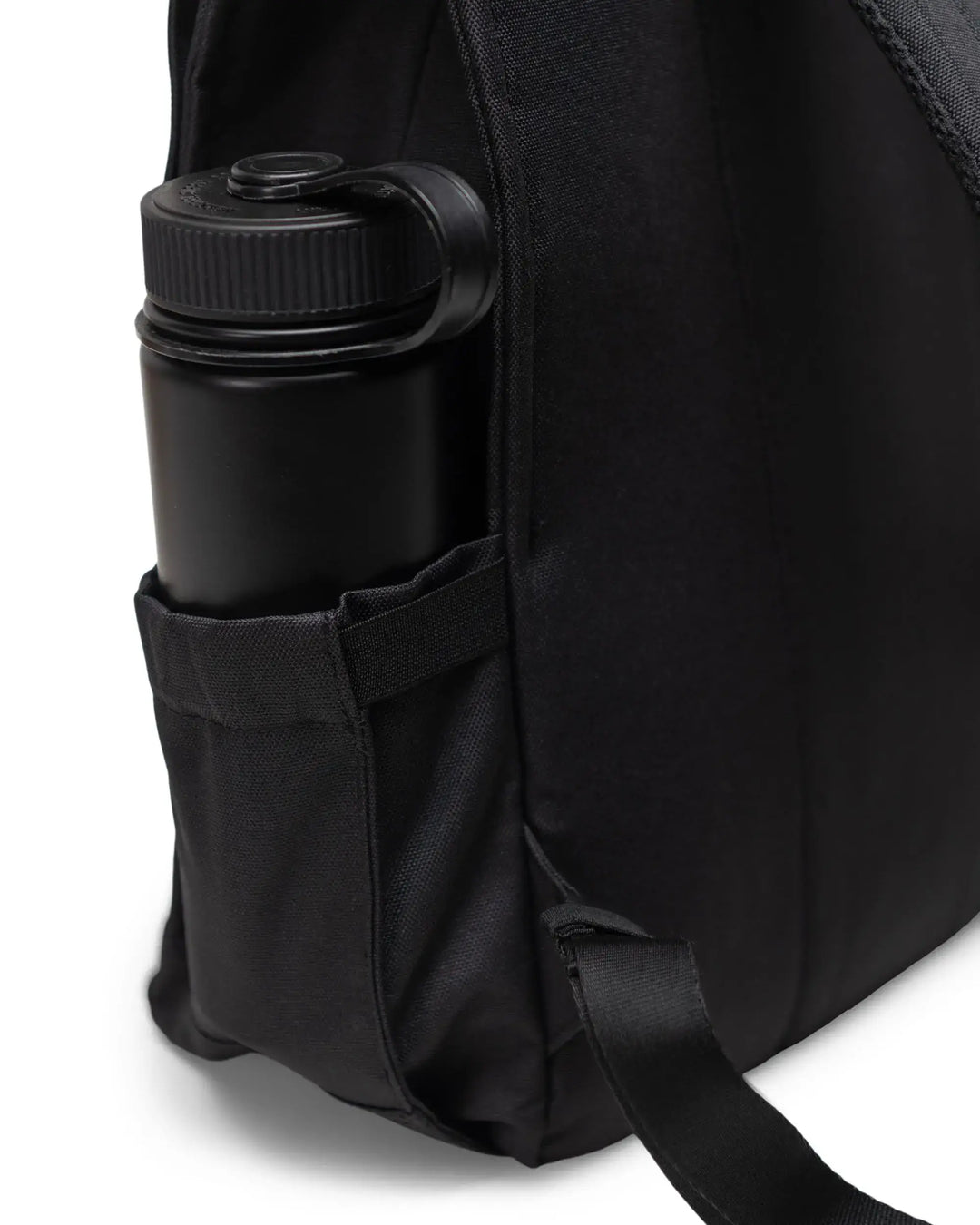 A closeup of a water bottle in a black backpack on a white background