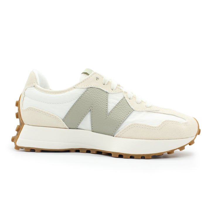 A white New Balance shoe shown from the side view. The sole is gum and wraps around the heel of the shoe. There is contrasting colors of white and cream throughout the shoe.