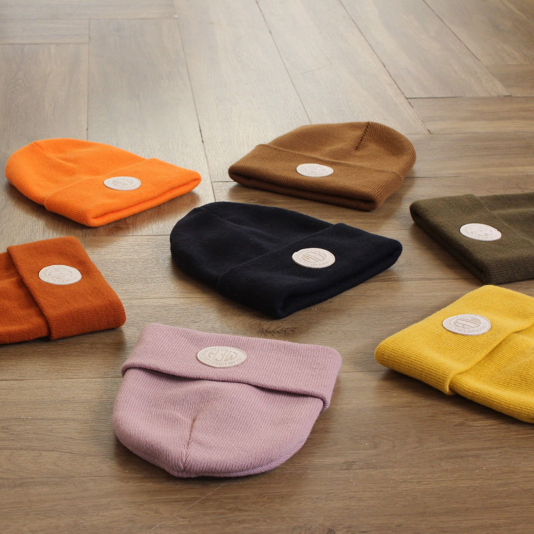 Set of colorful beanies on a wooden floor