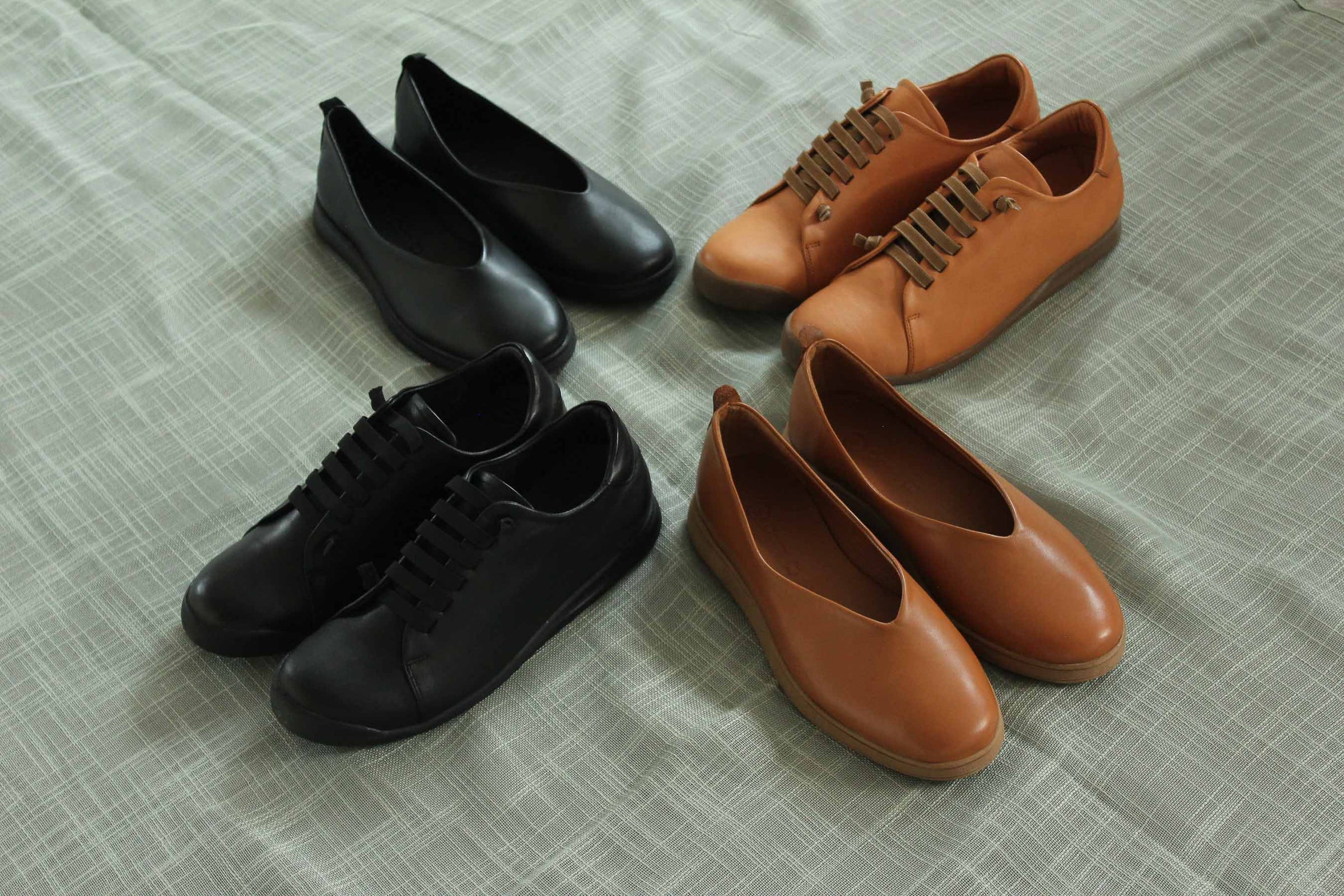 Pair of black shoes and a pair of brown shoes on a textured surface