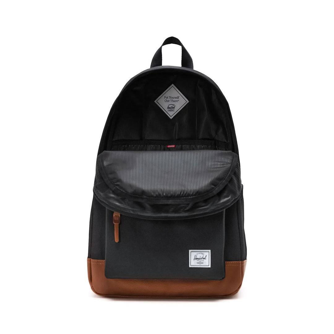 Black backpack with brown leather accents on a white background