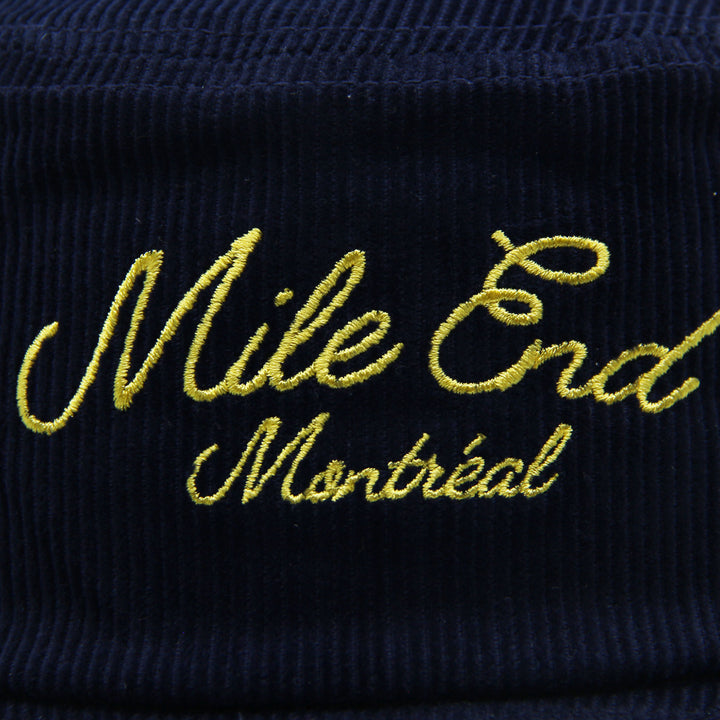 Navy blue corduroy hat with yellow embroidered text 'Mile End Montreal'