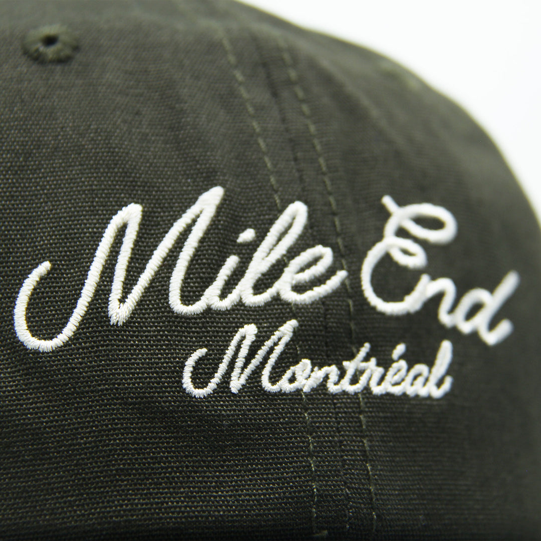 Green cap with 'Mile End Montreal' embroidered in white on a white background