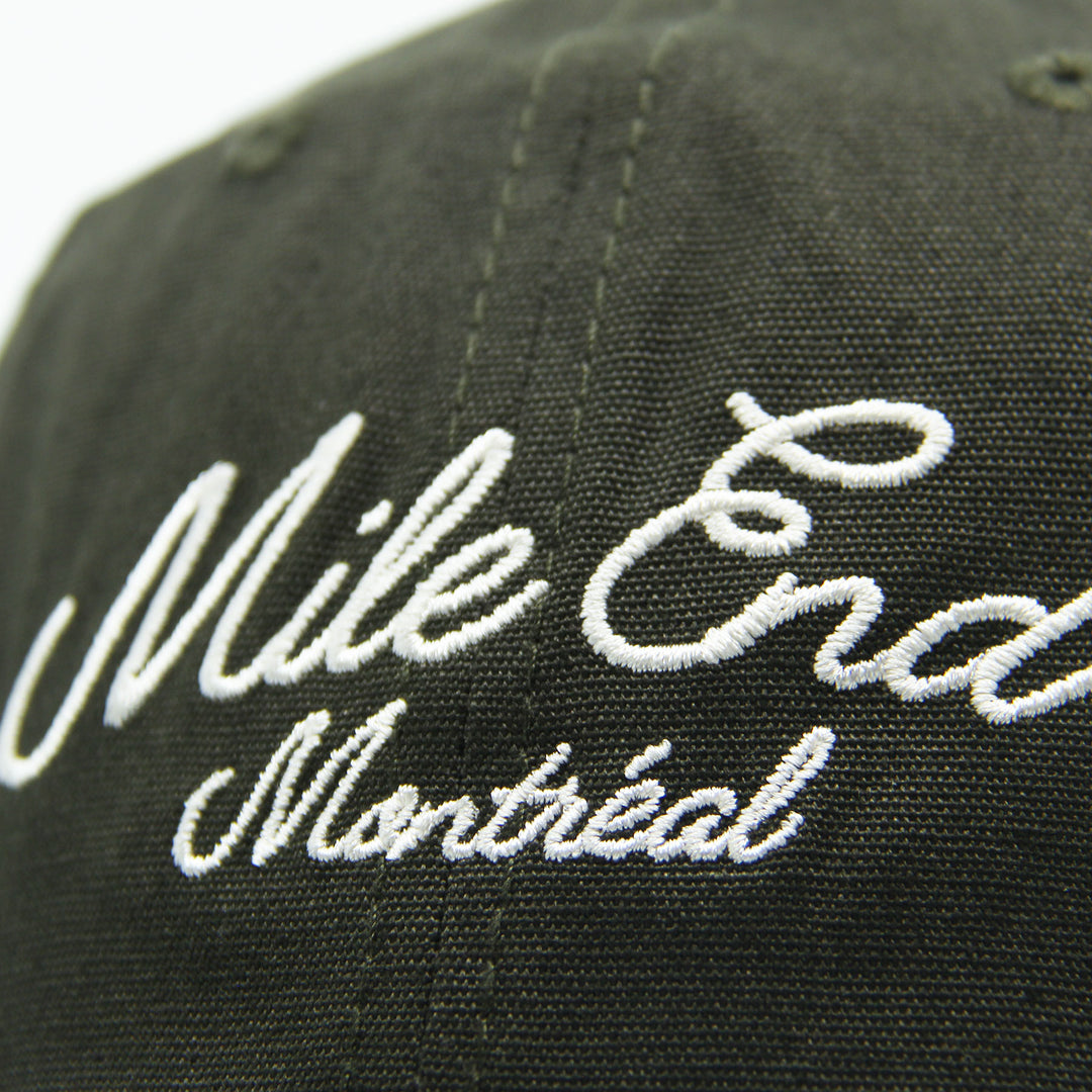Green cap with 'Mile End Montreal' embroidered in white on a white background