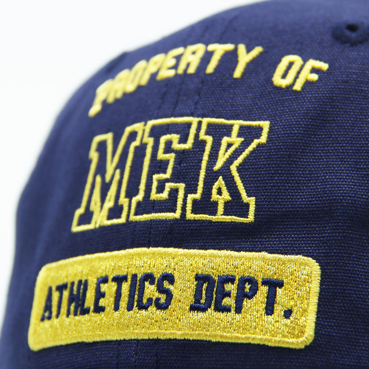 Navy blue cap with yellow text 'Property of MEK Athletics Dept.'