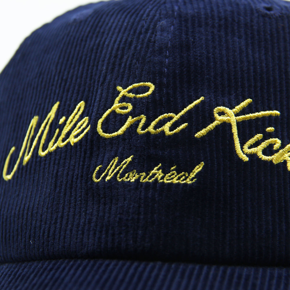 Navy blue cap with yellow embroidered text on a white background