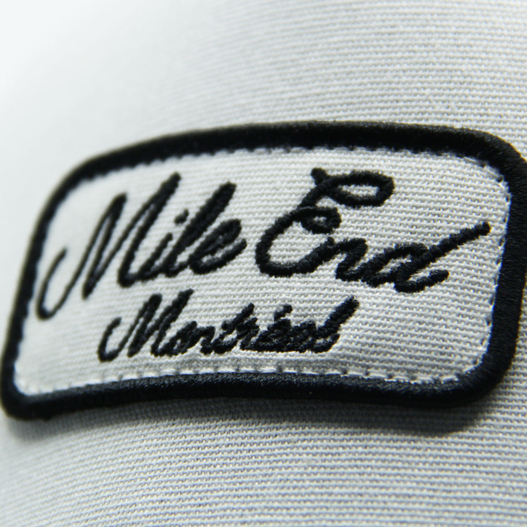 Embroidered patch with 'Mile End Montreal' text on a hat on a white background