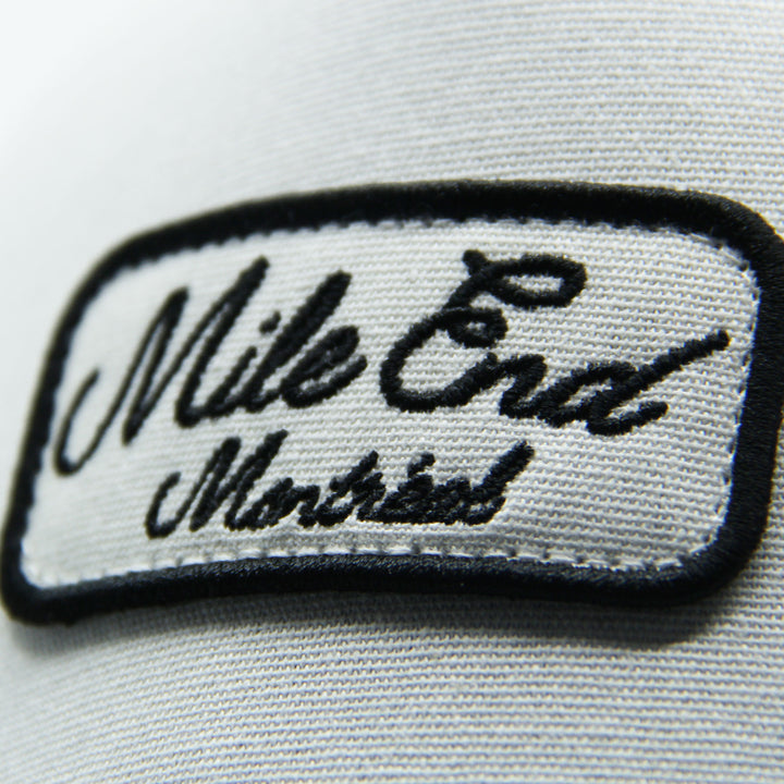 Embroidered patch with 'Mile End Montreal' text on a hat on a white background