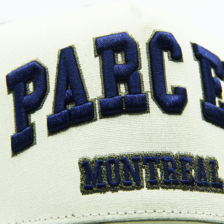 Close-up of a cap with 'PARC EX' and 'MONTREAL' text on a white background