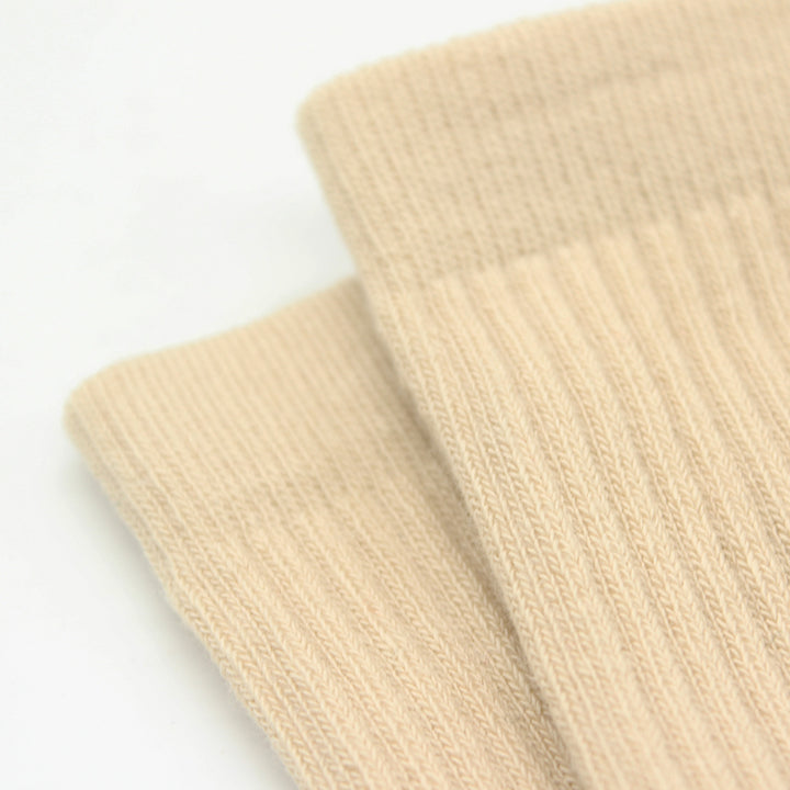 Close-up of beige knitted sock on a white background