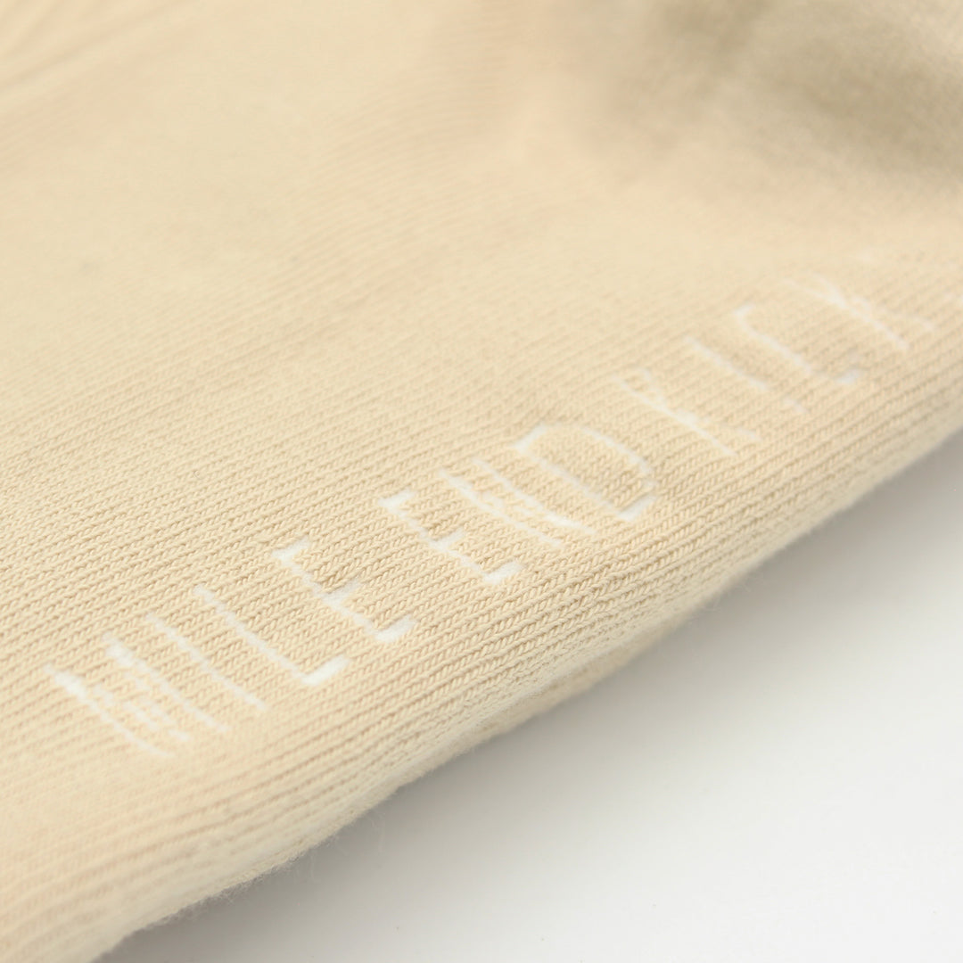 Beige sock with embroidered text on a light gray background
