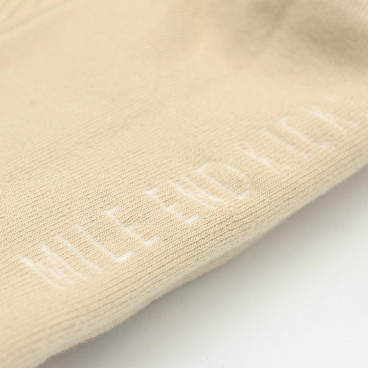 Beige sock with embroidered text on a light gray background