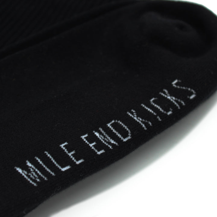 Black sock with 'Mile End Kicks' text on a white background