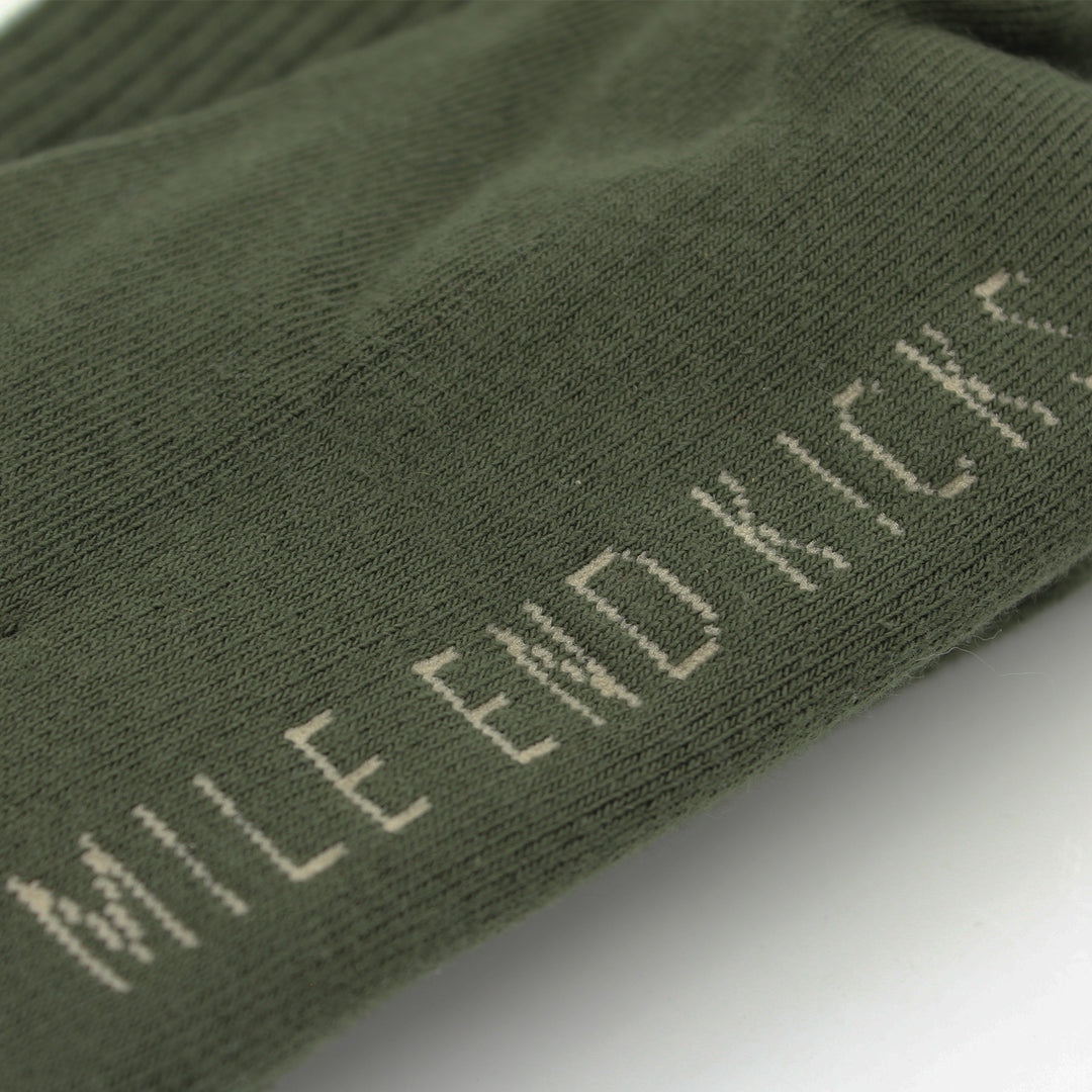 Green sock with 'Mile End Kicks' branding on a white background