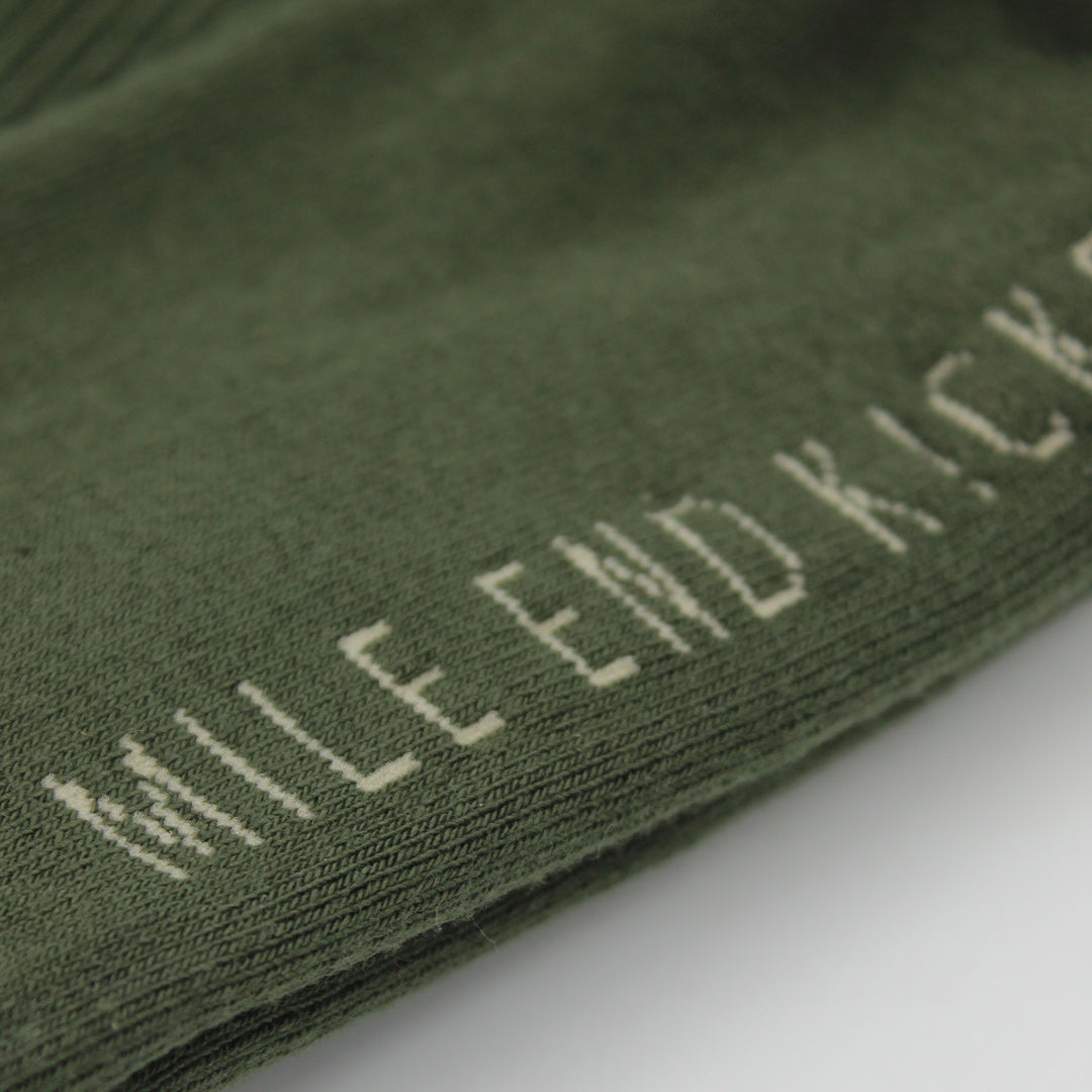 Green sock with 'Mile End Kicks' text on a white background