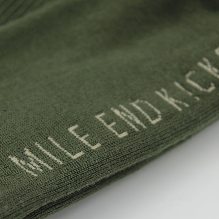 Green sock with 'Mile End Kicks' text on a white background