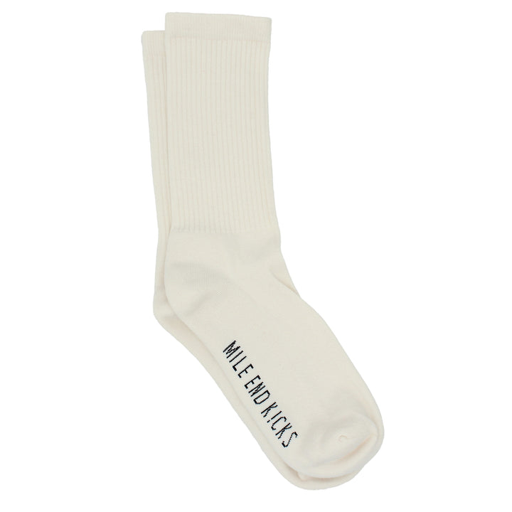 A pair of cream colored socks on a white background.