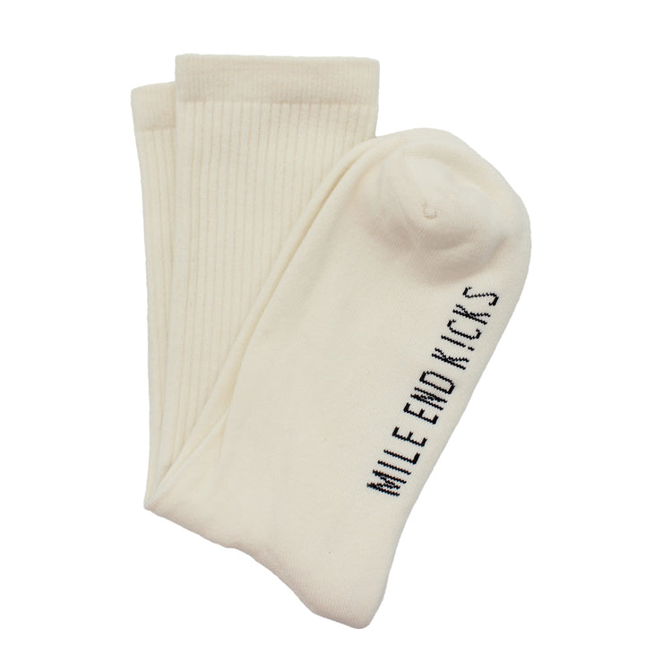 Pair of cream socks with 'Mile End Kicks' text on a white background