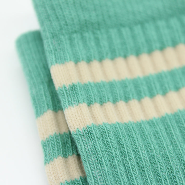 Close-up of green and beige striped socks on a white background