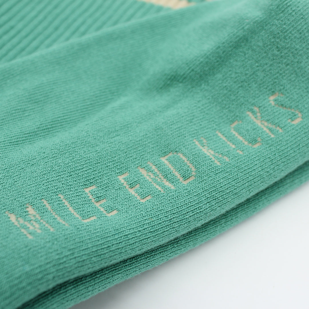 Green sock with 'Mille End Kicks' text on a light gray background
