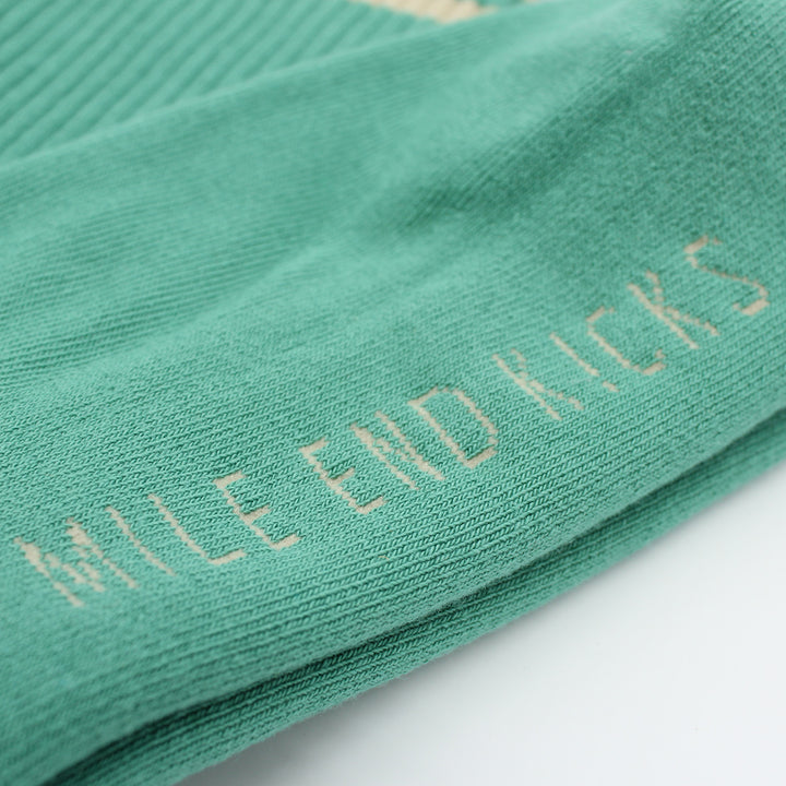 Green sock with 'Mille End Kicks' text on a light gray background