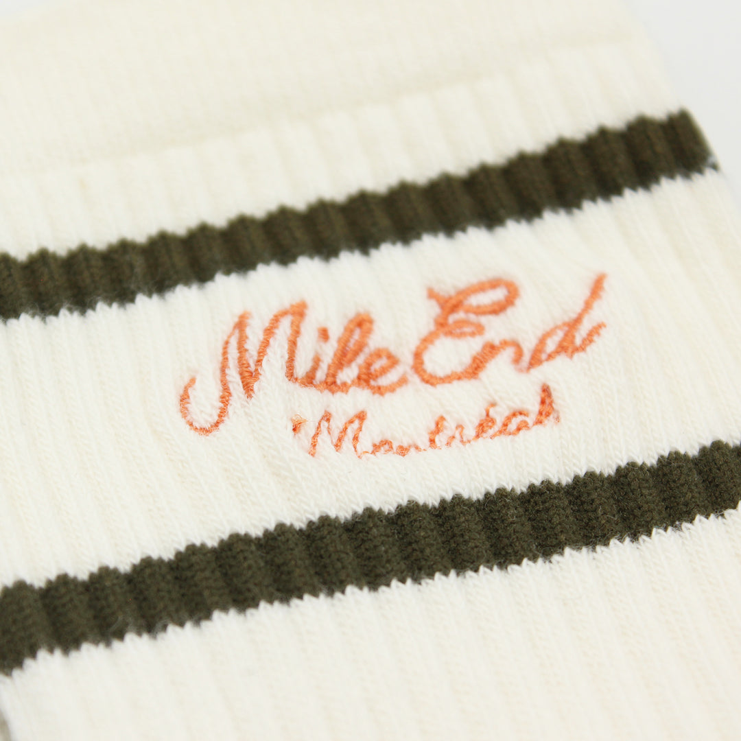Close-up of striped socks with 'Mile End' embroidery on a white background