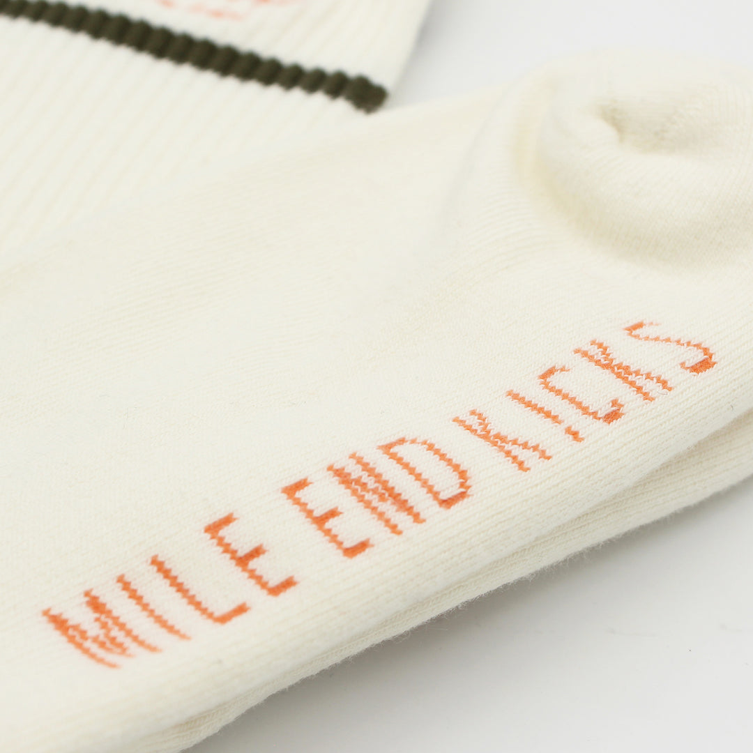 Close-up of a white sock with orange text on a light background