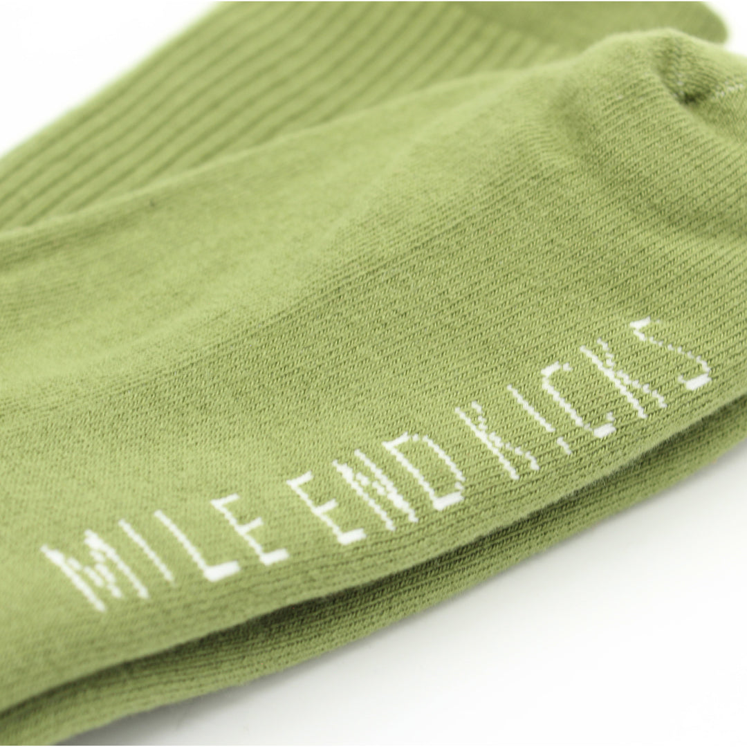 Green sock with 'Mile End Kicks' text on a white background
