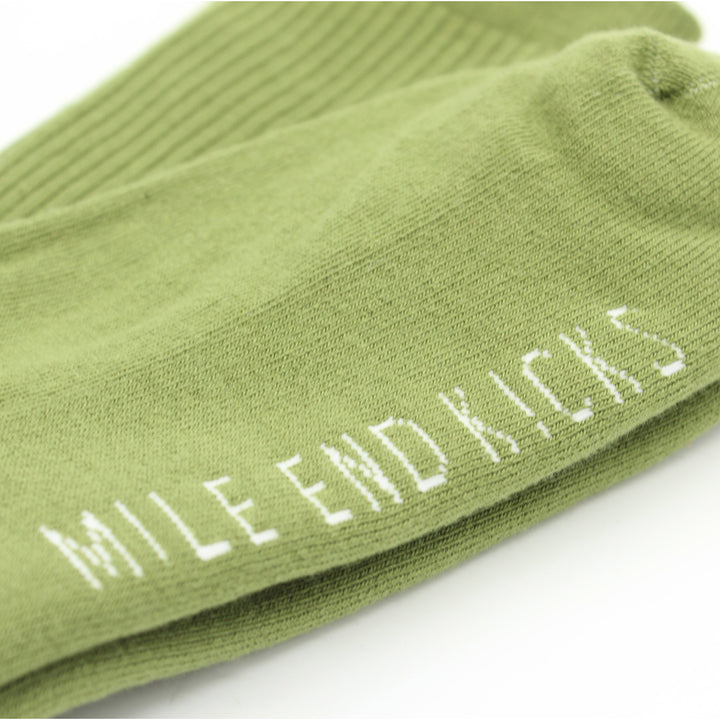 Green sock with 'Mile End Kicks' text on a white background