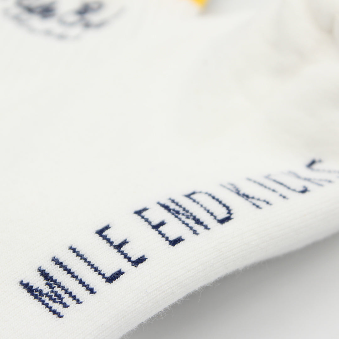 Close-up of white socks with embroidered text on a blurred background