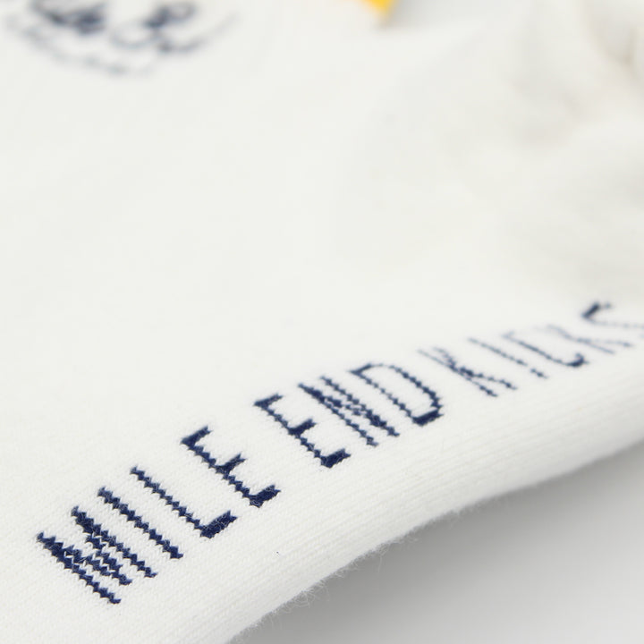 Close-up of white socks with embroidered text on a blurred background