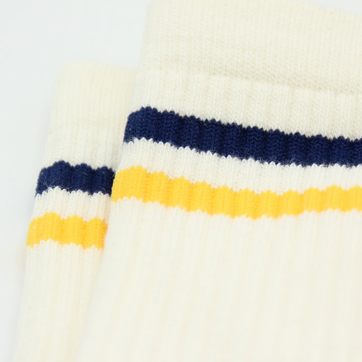 Close-up of a knitted sock with blue and yellow stripes on a white background