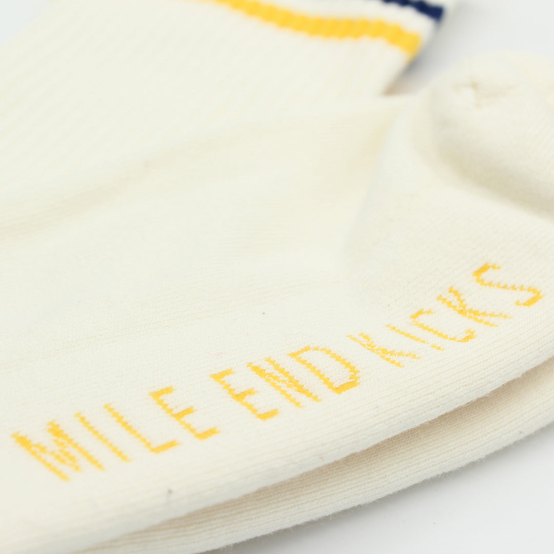 Close-up of a white sock with yellow text 'Mile End Kicks' on a white background