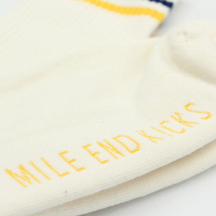 Close-up of a white sock with yellow text 'Mile End Kicks' on a white background