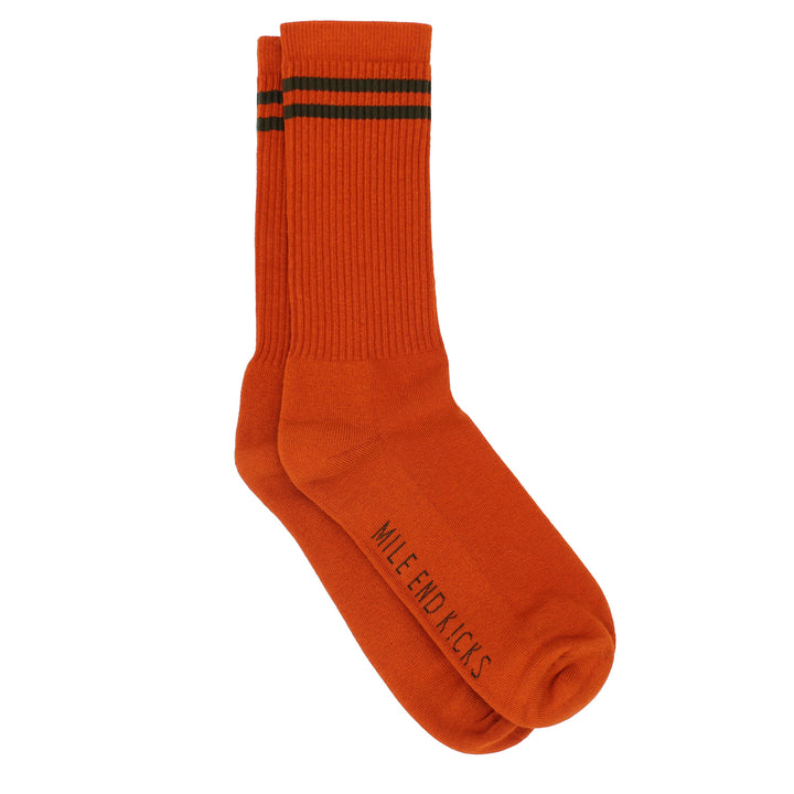Orange sock with green stripes on a white background