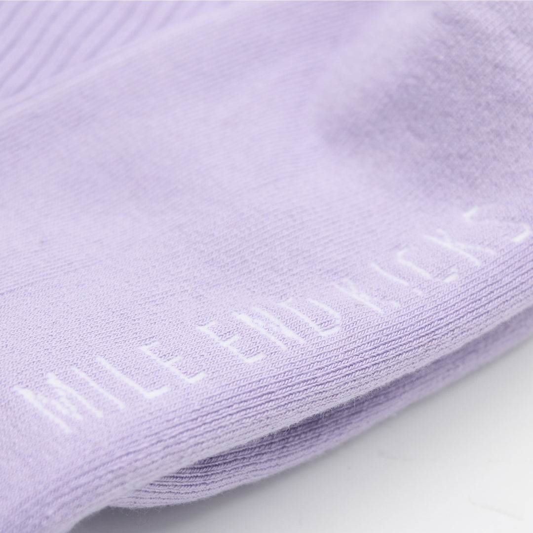 Close-up of purple socks with a brand logo.