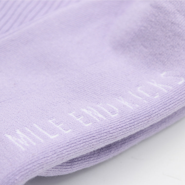 Close-up of purple socks with a brand logo.