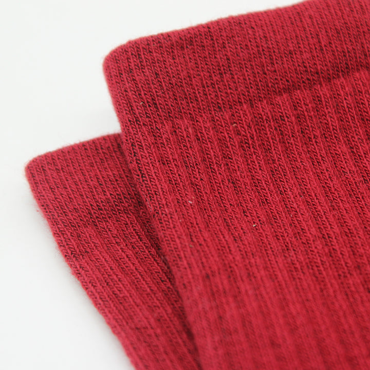 Two red socks stacked on a light gray background