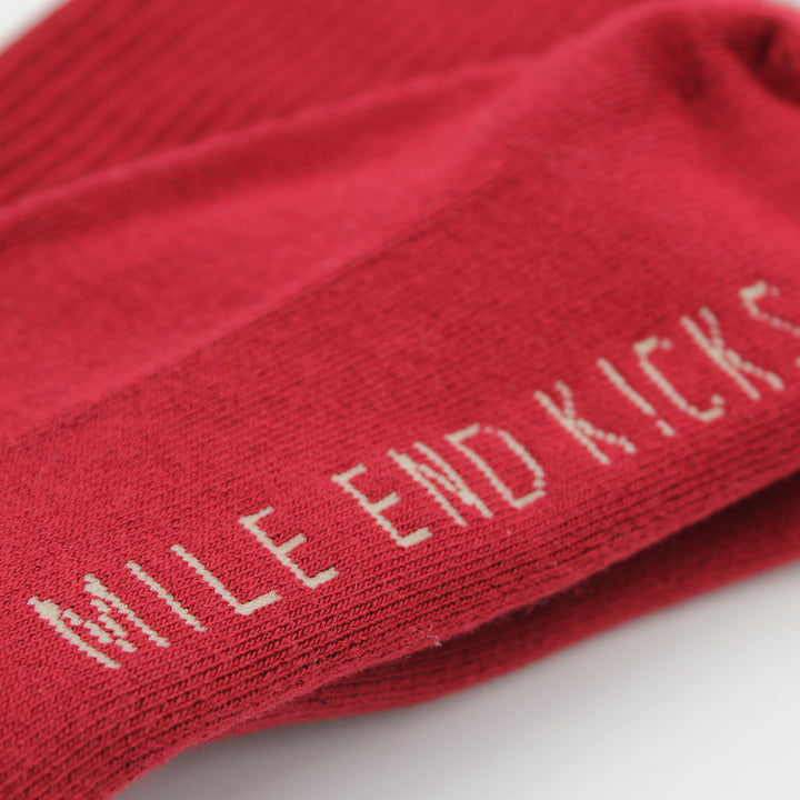 Red sock with 'Mile End Kicks' text on a white background