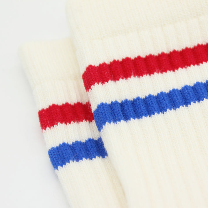 Close-up of white socks with red and blue horizontal stripes.