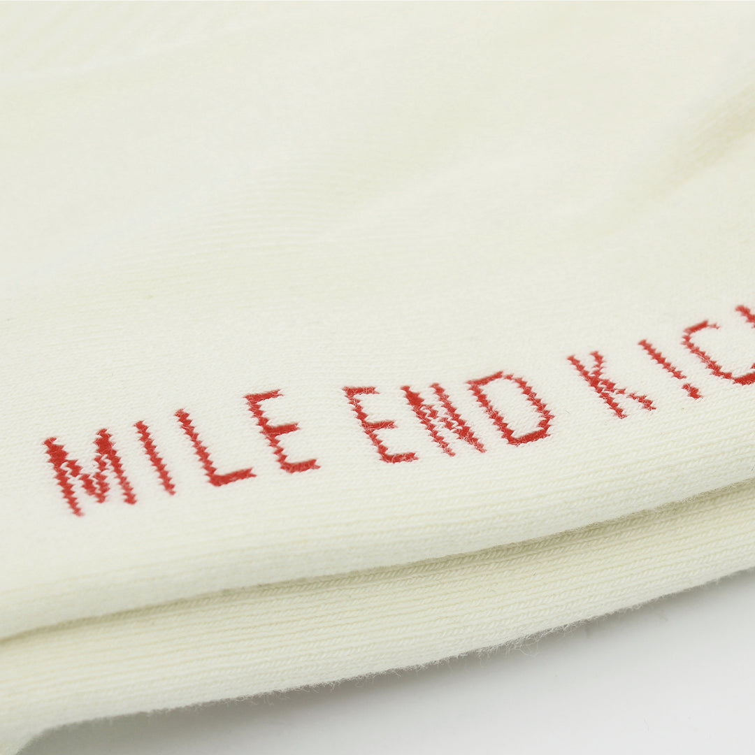 White socks with red embroidered text on a white background