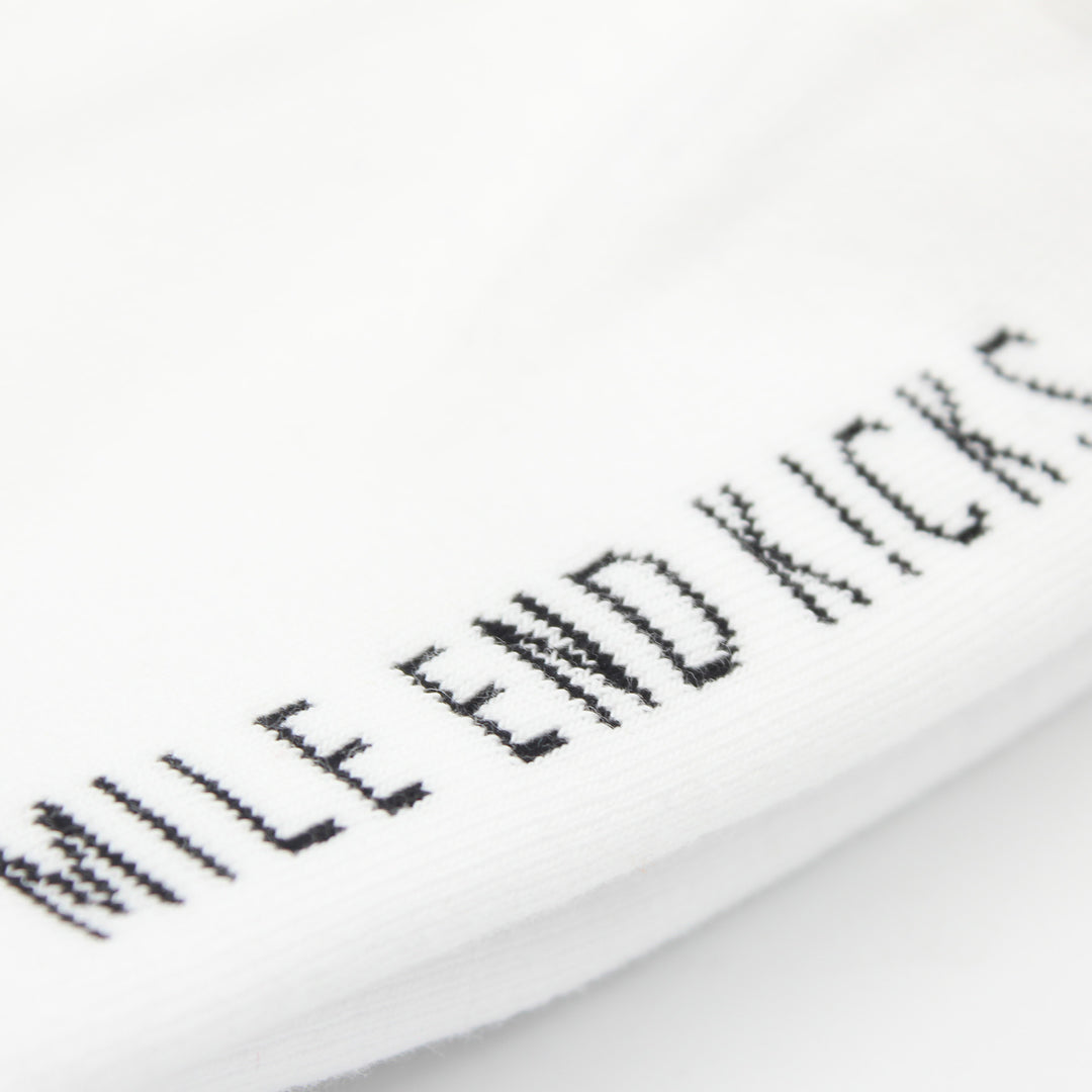 Close-up of a white sock with black text on a white background