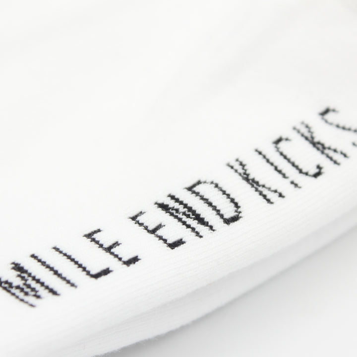 Close-up of a white sock with black text on a white background