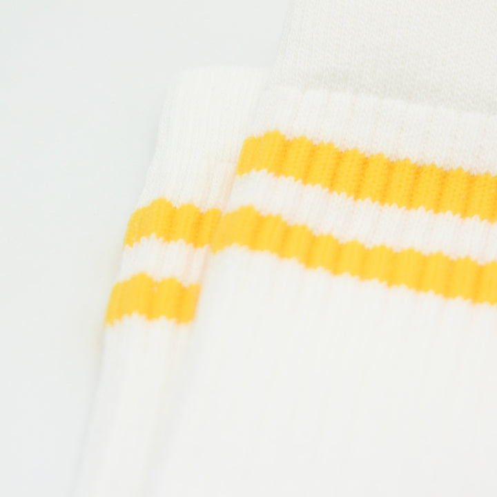 Close-up of a white sock with yellow stripes on a white background
