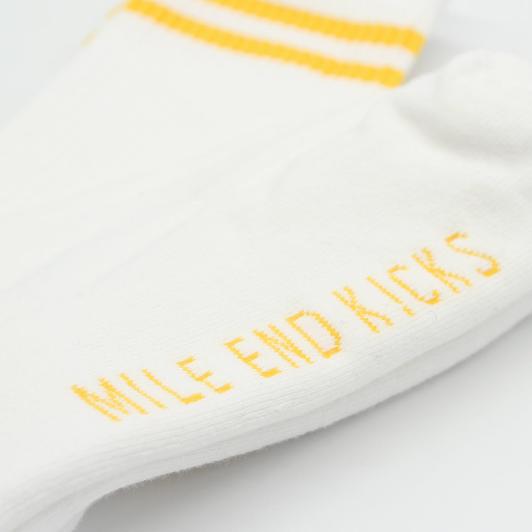 White sock with yellow text and stripes on a light gray background